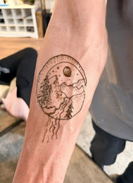 high quality, custom, men's henna tattoo featuring a mountain nightscape with a waterfall, inside of a crescent moon, for a male guest at a graduation in Gilbert, Arizona.