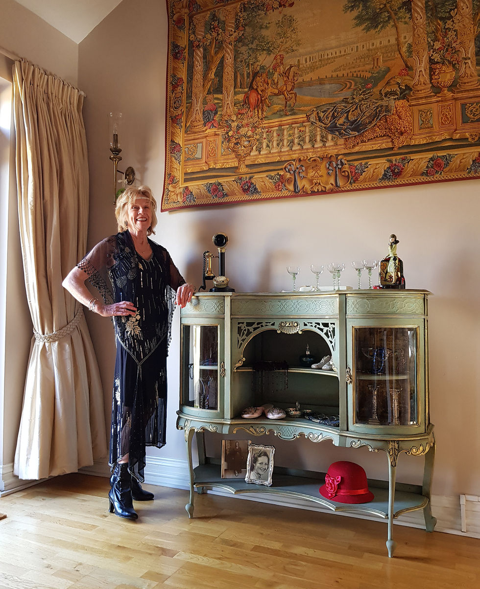 lady dressed in flapper clothes next to hand painted vintage turquoise french sideboard under tapestry wall hanging