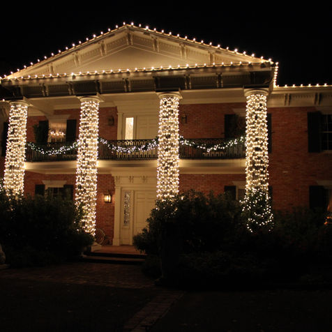 House with hand wrapped pillars and balcony with garland 