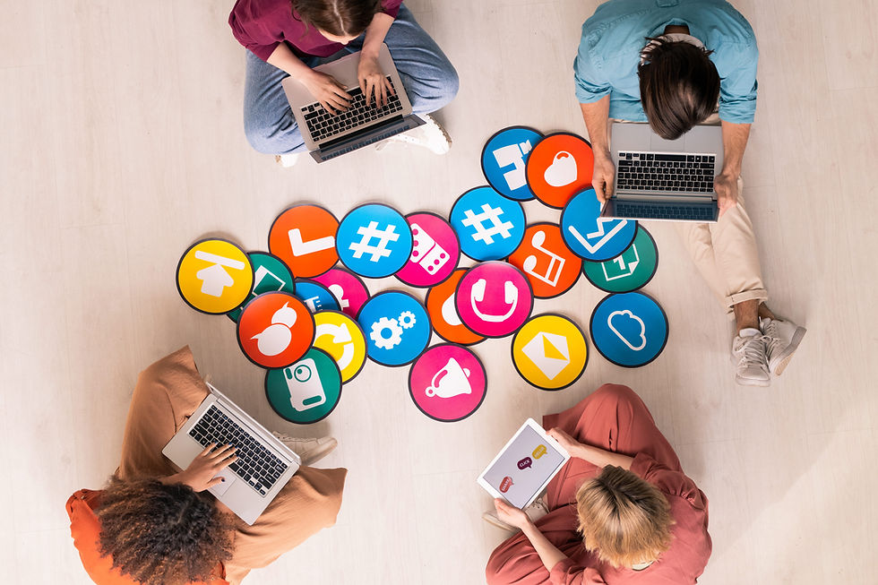 Un equipo de 4 personas trabaja en sus laptops y tablets, con varios icónos representando una lluvia de ideas