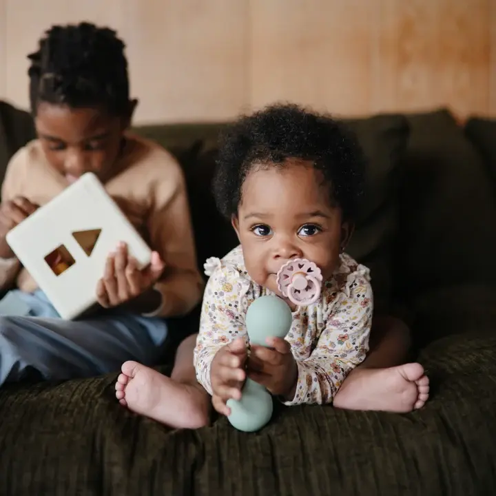 Thumbnail: Baby holding sage green tradition baby rattle by Mushie