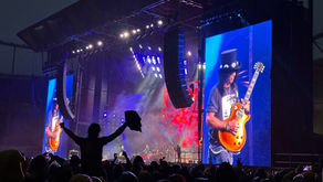 Slash performing live during Guns N' Roses Tour 2025 in Kaunas at Darius and GirÄ—nas Stadium, with stage lights and crowd visible.