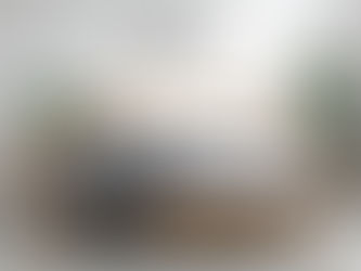 Ein Bett aus Massivholz mit grauen kuscheligen Decken und einer Katze, die am Bett schläft