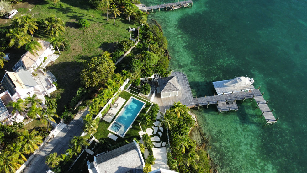 an aerial view of a stunning home with a pool and a dock in Harbour Island