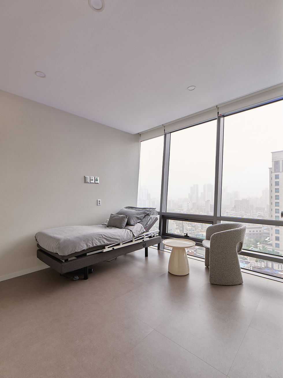 Relaxing recovery room inside a luxury Korean aesthetic clinic, soft lighting and single bed setup