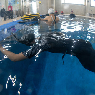  Freediver floating face down, holding breath in static apnea training at pool