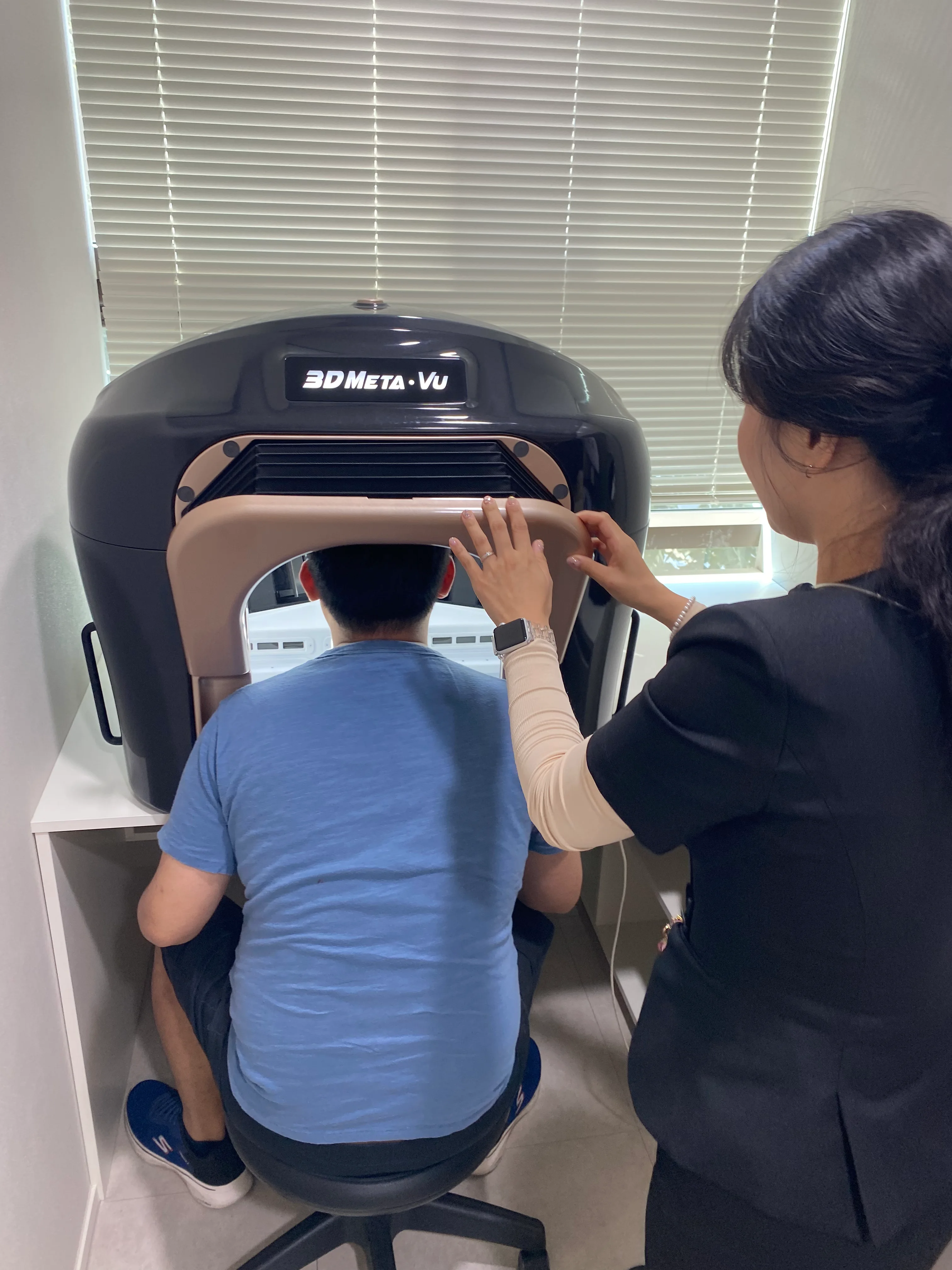 Photo of a skin analysis being performed with a digital skin scanner in a Korean dermatology clinic, showing the device capturing detailed facial images in a clean, bright setting