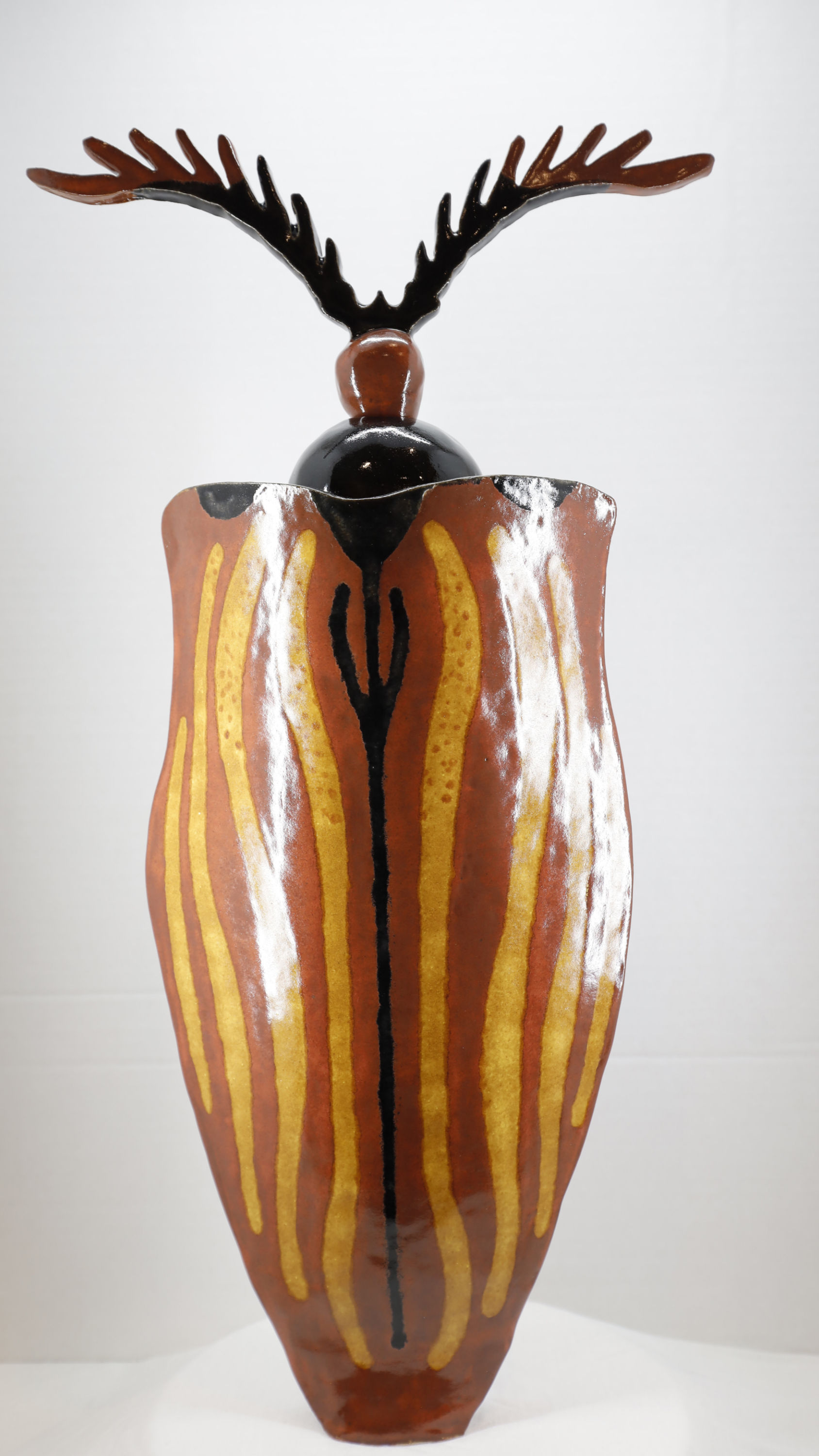 Decorative ceramic vase with an antler-like top and vertical stripes design.