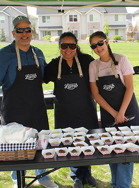 three people serving free lamb samples