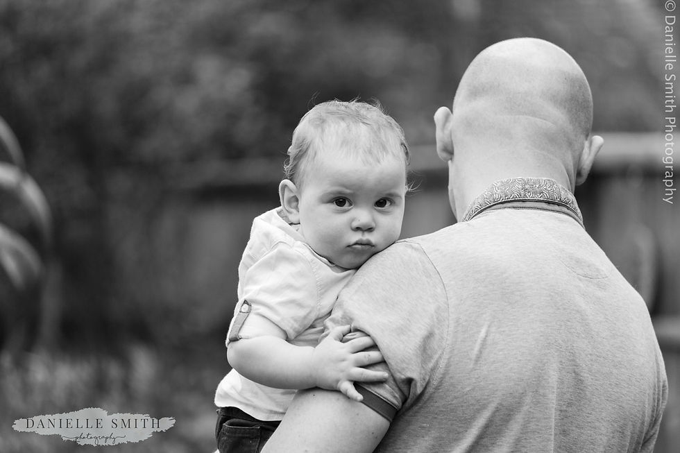 baby boy looking at camera in dads arms
