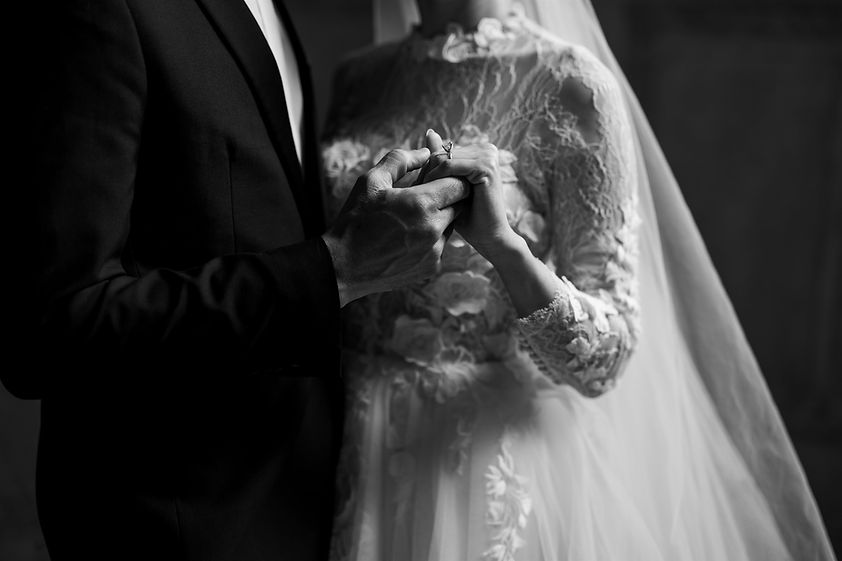 black and white detail photo of bride and groom holding hands