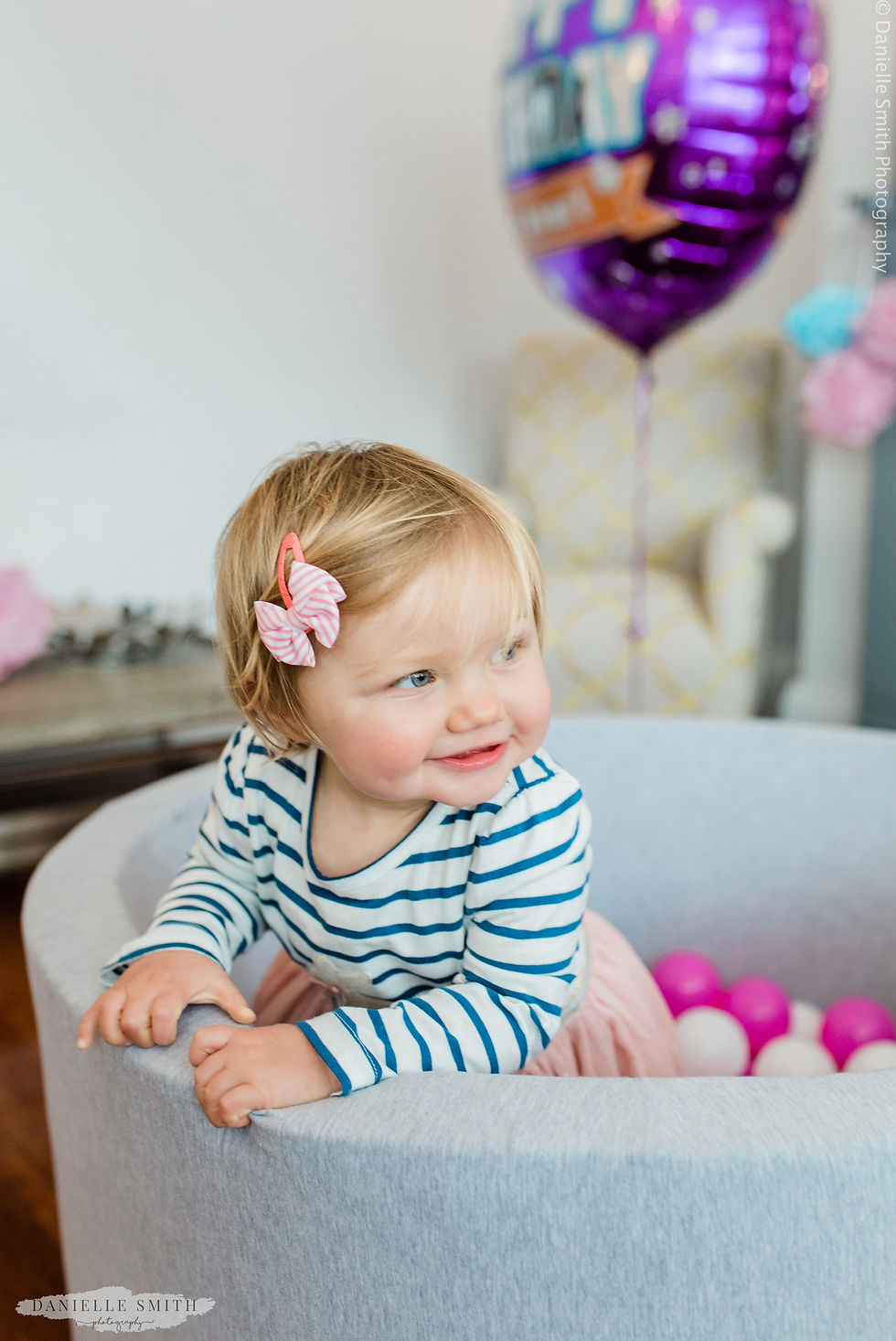 little girl standing in ball pool