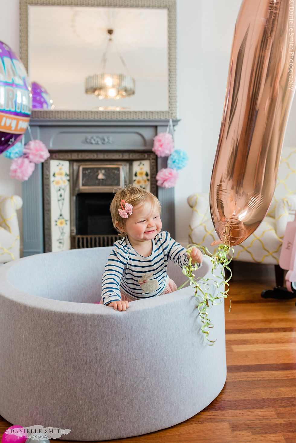girl with first birthday balloon