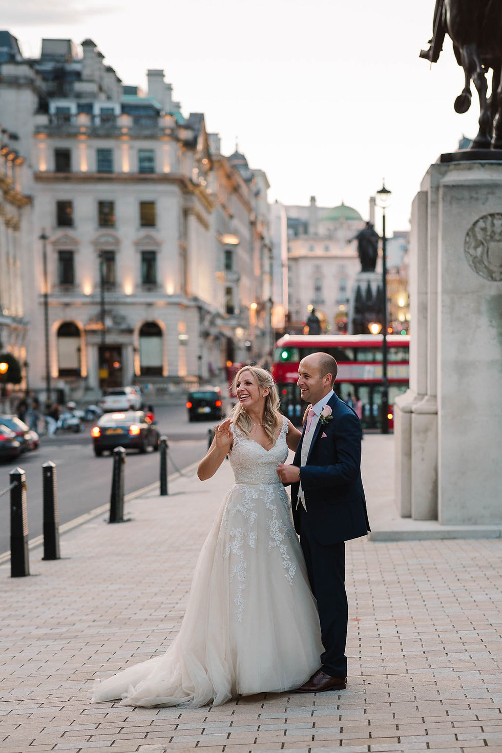 bride and groom waving at passers by in London