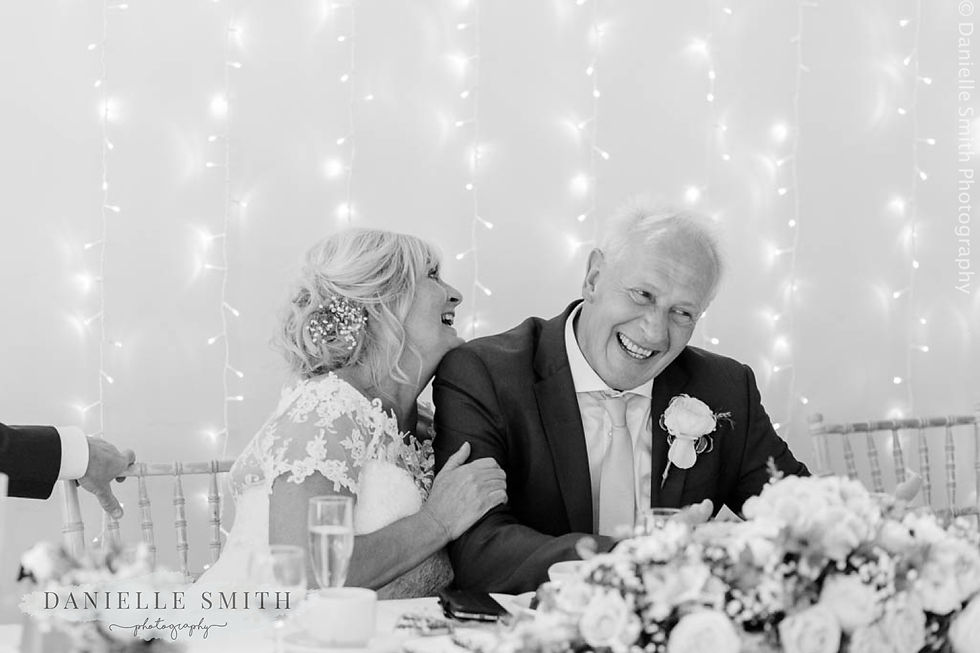 bride and groom laughing at top table