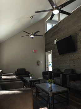 The interior of an office waiting room with gray walls, floors, and furniture.