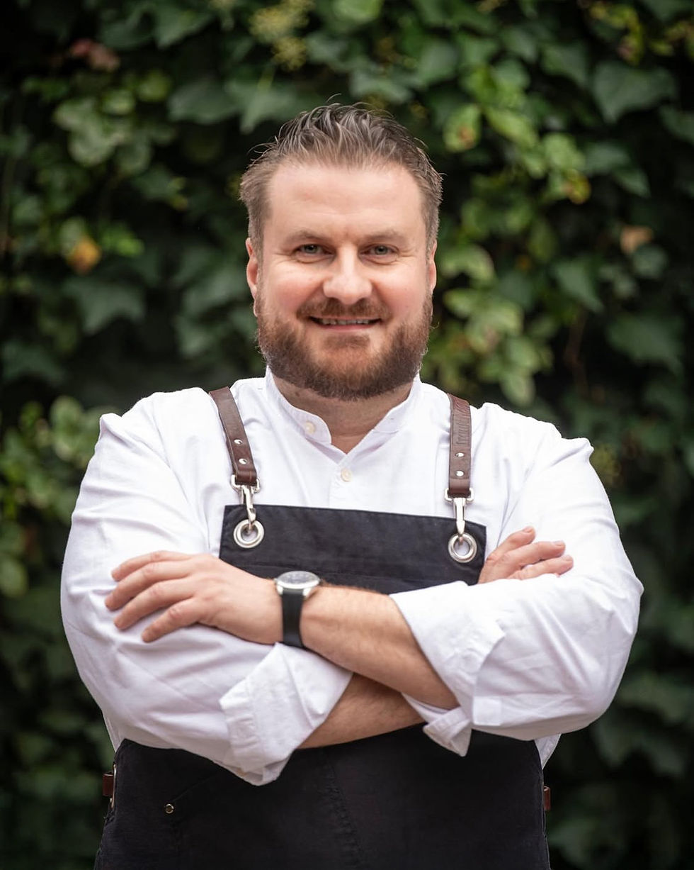 Porträt von Vjekoslav Pavic in Kochjacke und Schürze vor der Brasserie in Pirmasens