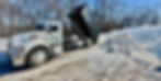 dump truck dumping snow that was removed from another location 