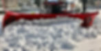 a large truck plowing snow on an angle 