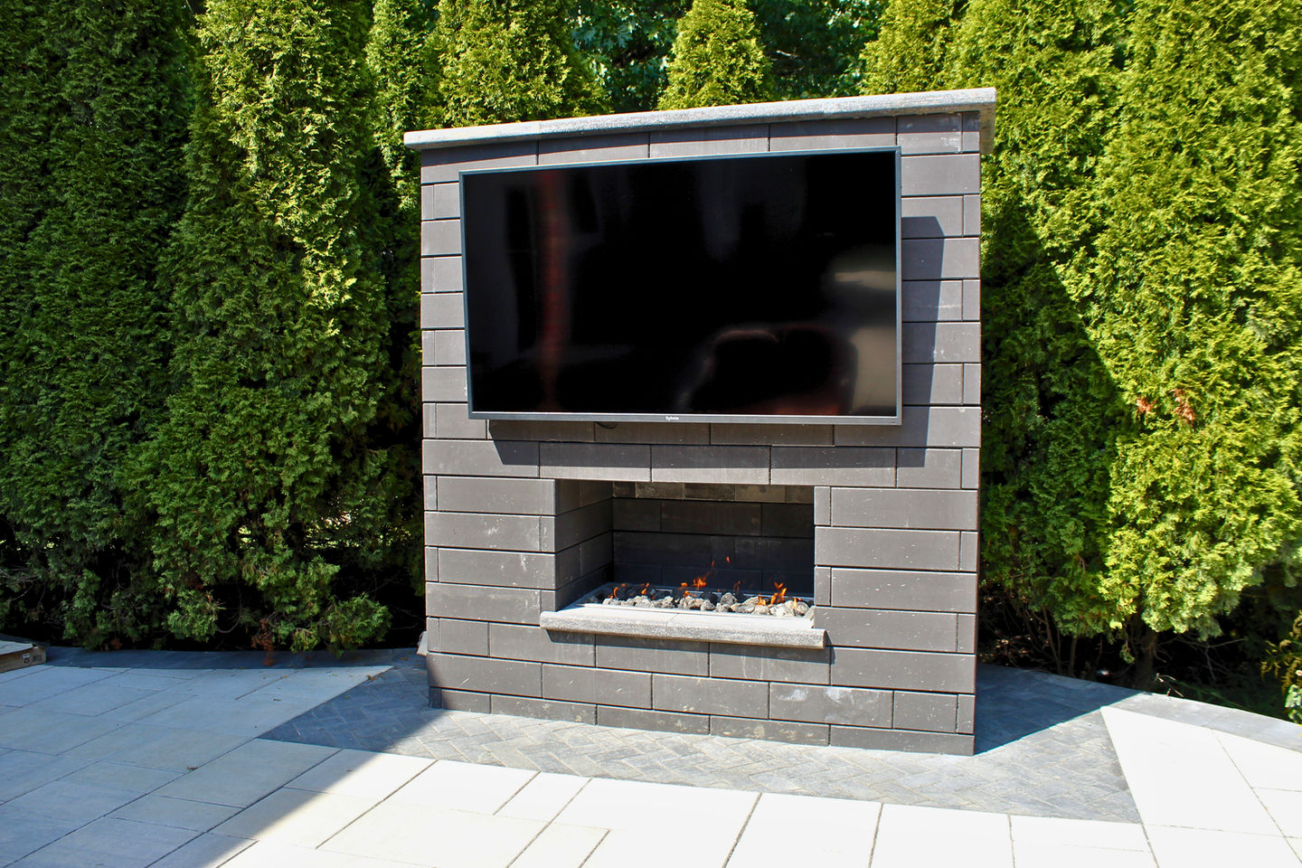 Outdoor fireplace feature integrated into patio hardscape design