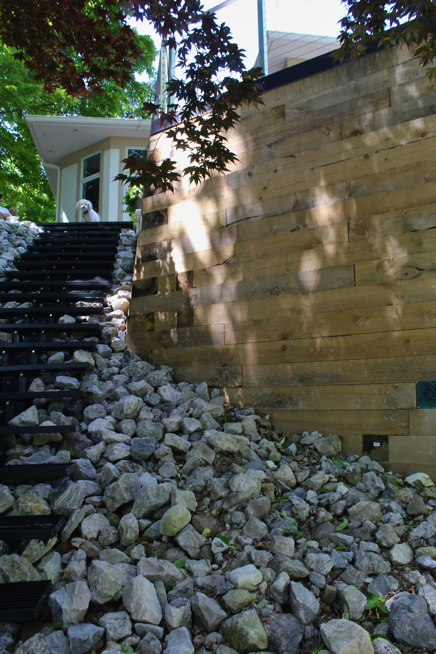 Retaining wall and stair construction with rock base and timber detail