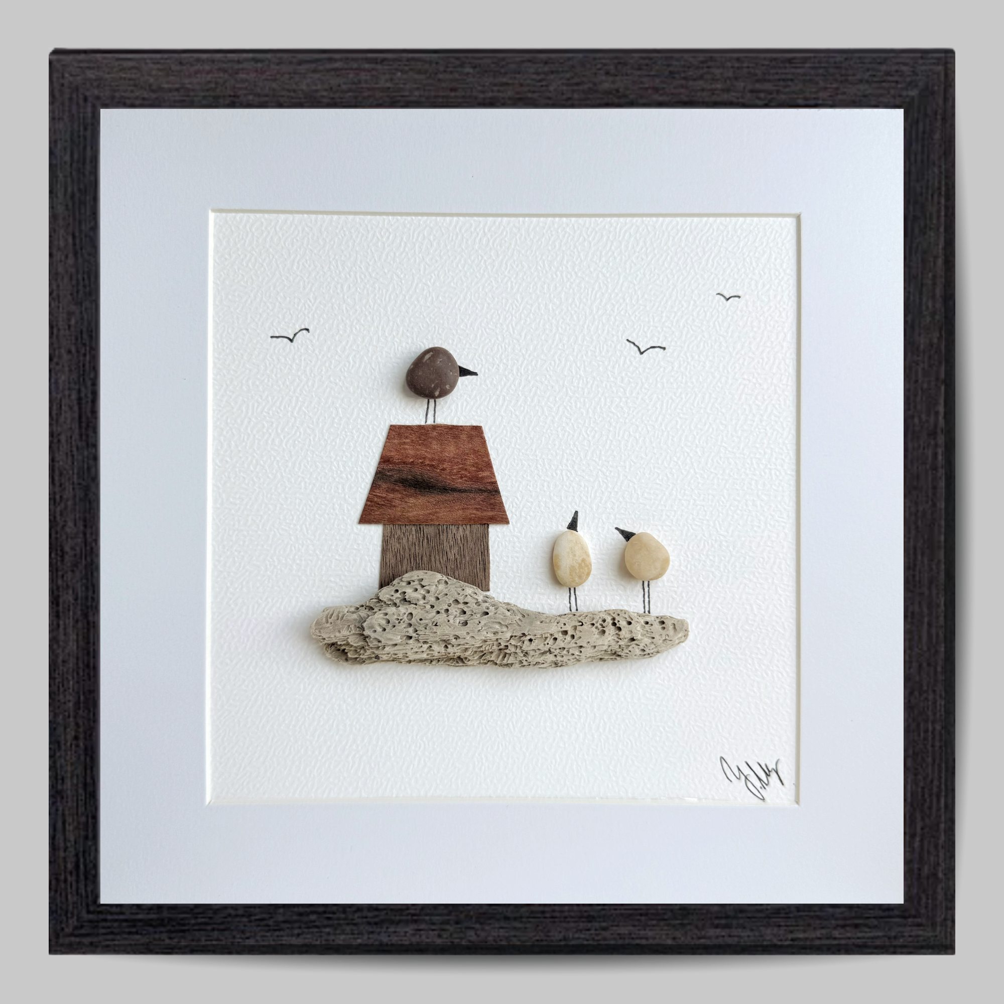 Handgefertigtes Kieselsteinbild mit drei Vögeln aus Natursteinen, kleinem Haus aus Edelholz und Treibholz – maritimes Steinbi