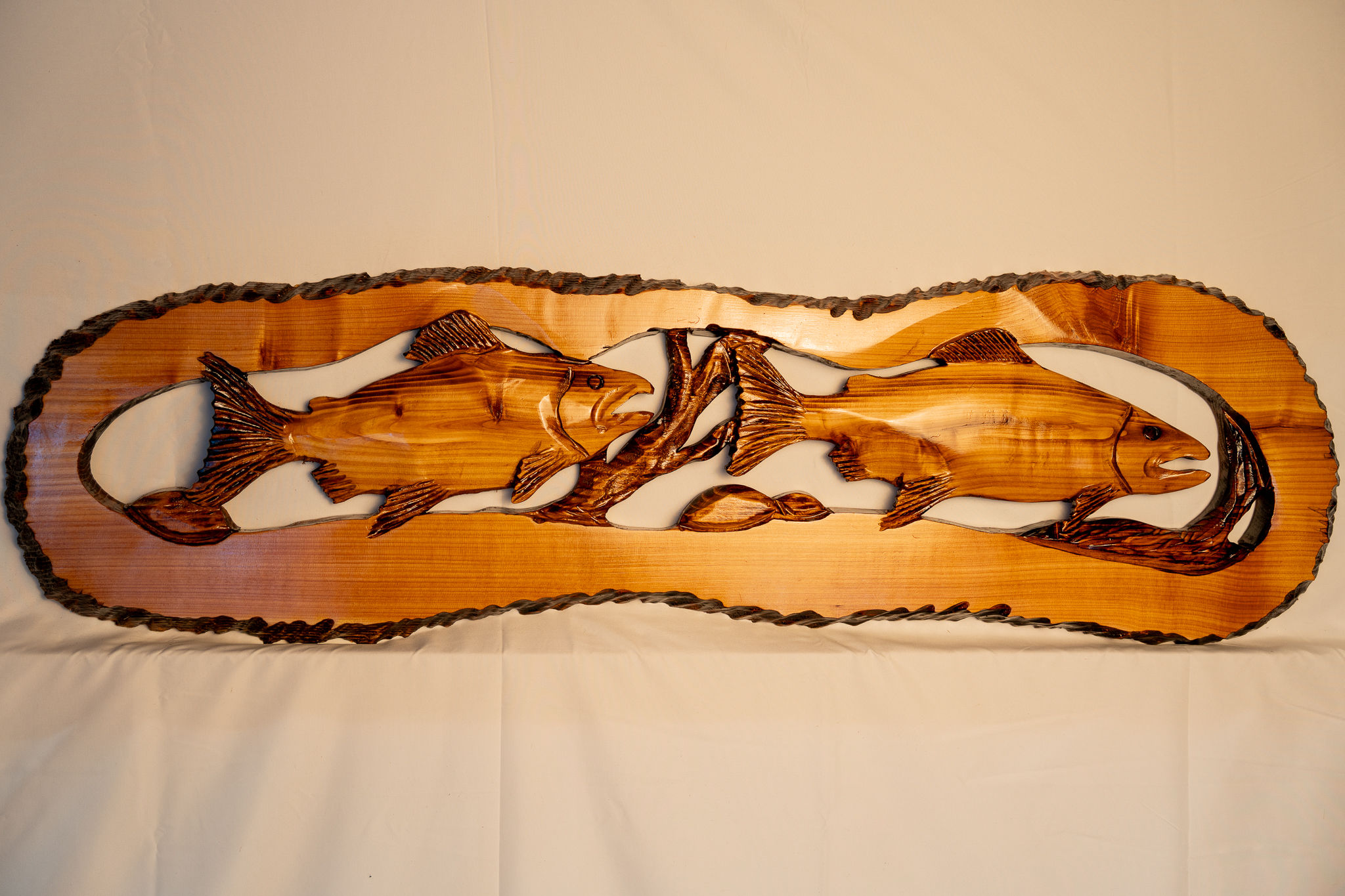 Featuring salmon swimming through a forest creek, this carving brings together the rugged beauty of water and wildlife.