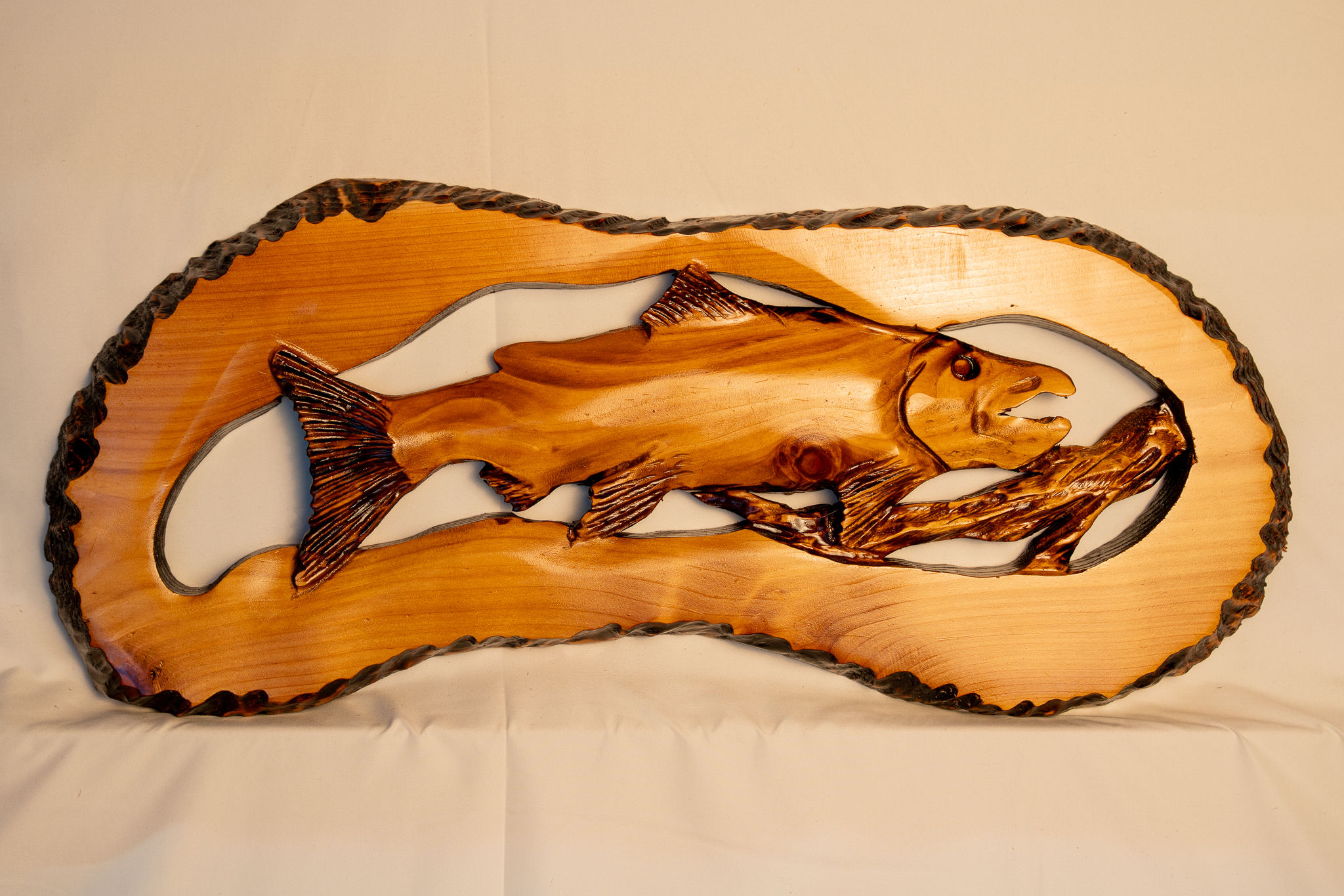Featuring salmon swimming through a forest creek, this carving brings together the rugged beauty of water, and wildlife