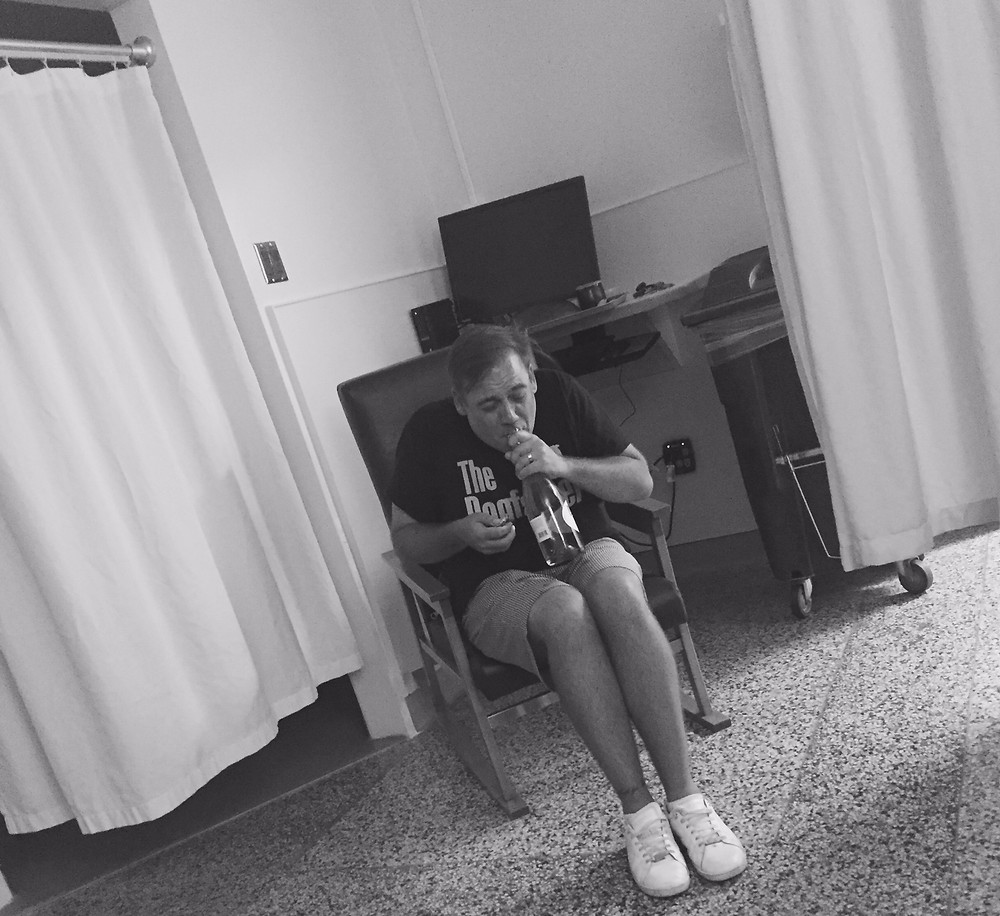 Proud new dad pops the bottle of champagne in the hospital to celebrate--Congrats!