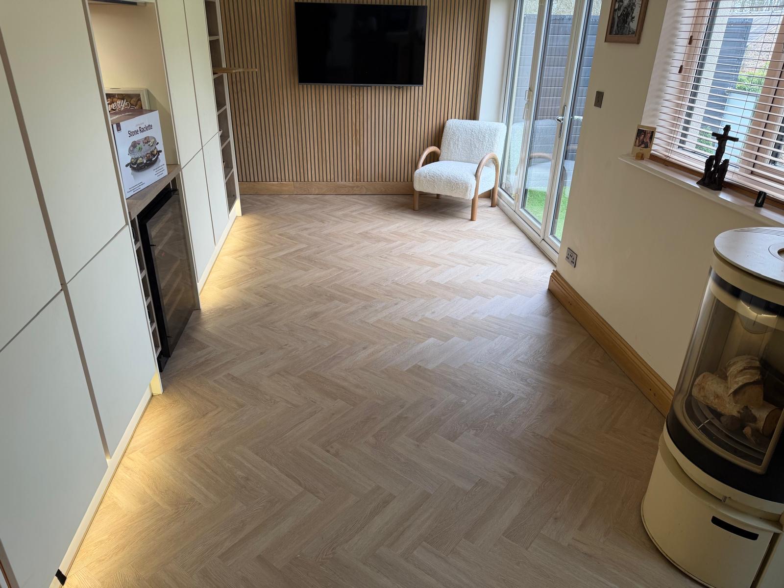 Light wood-effect herringbone flooring in a bright living space