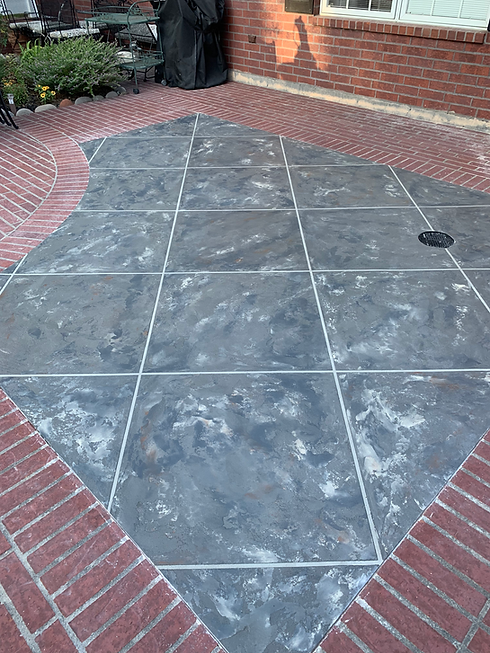 Patio with dark gray tiles and brick border