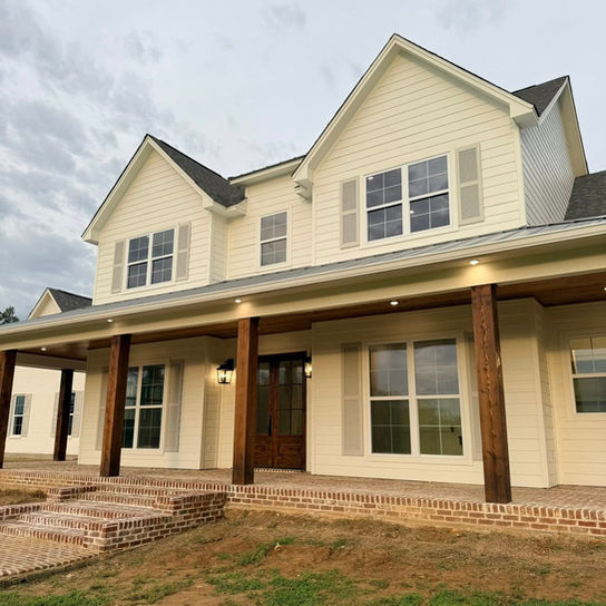 Two-story cream house with a wide dark-columned front porch