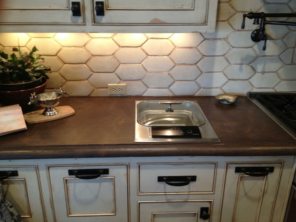 Kitchen counter with dark decorative concrete, sink, and honeycomb backsplash