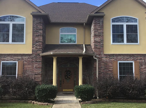 Front view of a house with windows and a brown door