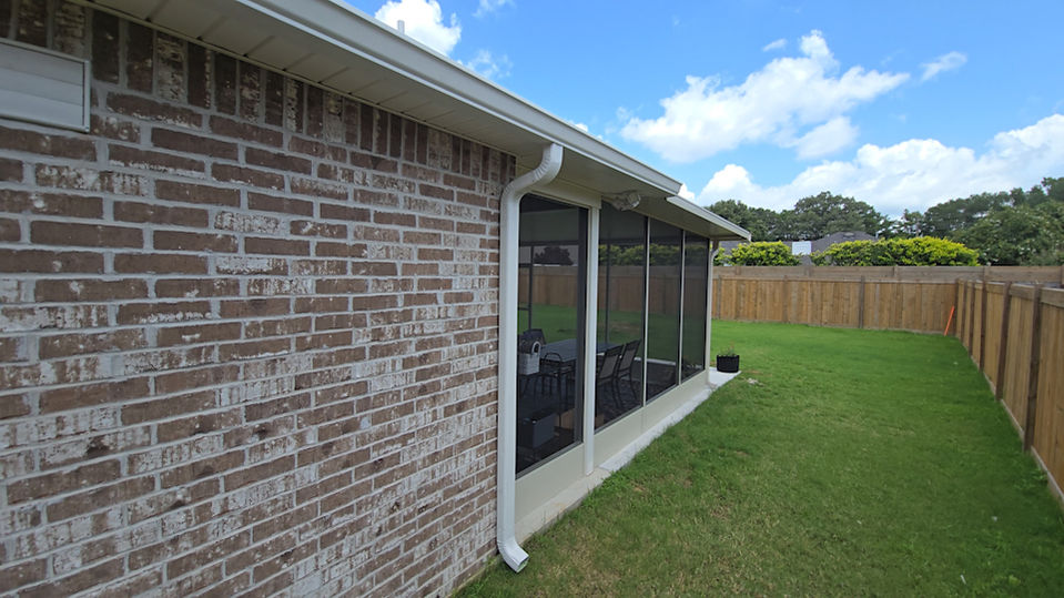 Screened patio with brick wall and yard