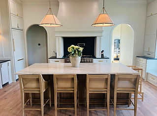 Modern kitchen with large island, bar stools, white flowers