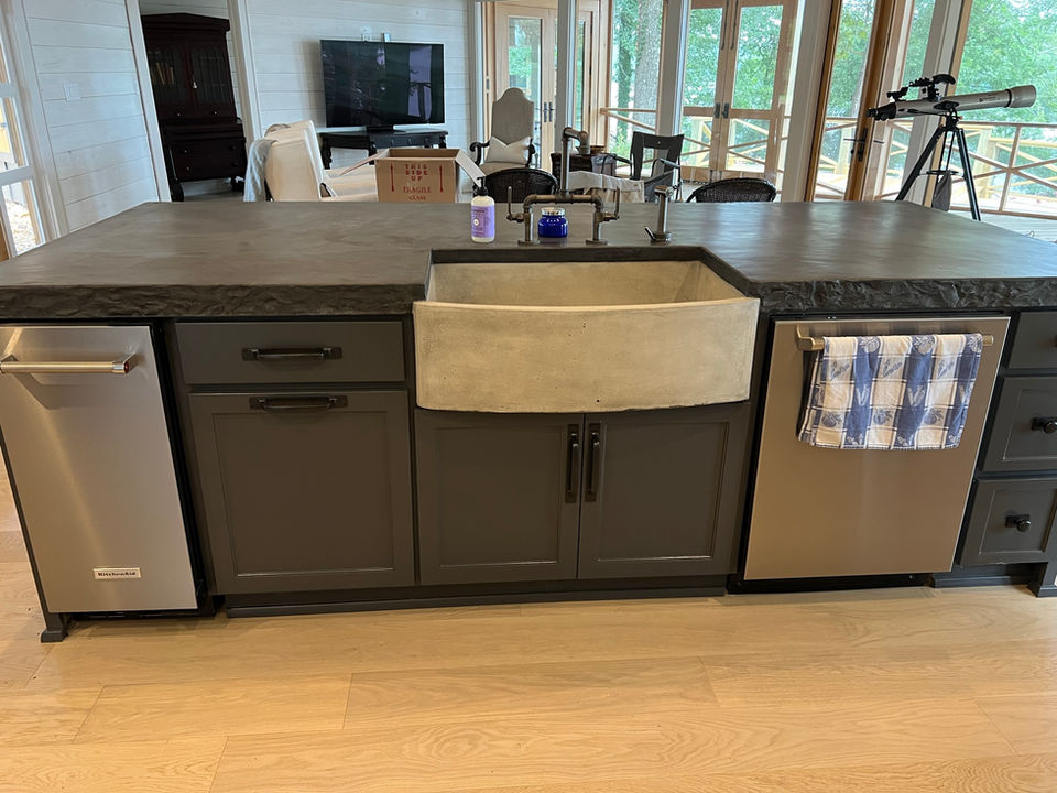 Kitchen island with decorative concrete countertop and farmhouse sink