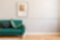 Green sofa with throw, abstract art
