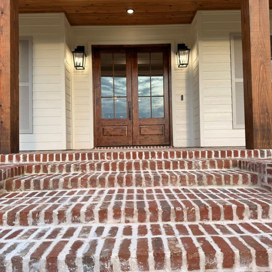 Brick steps to a house with double wood doors