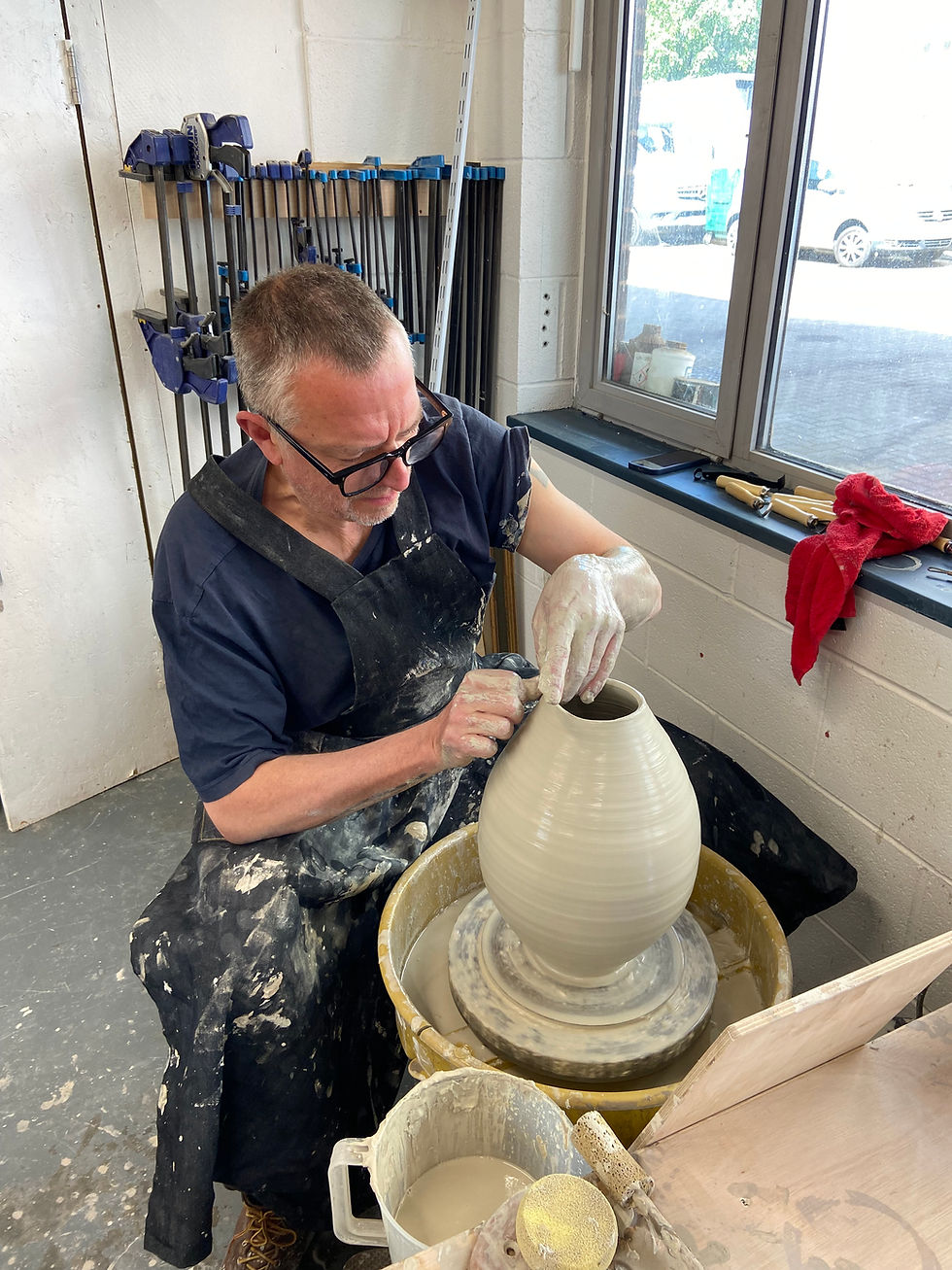 Ian-Burgess-making-a-pot-on-a-potters-wheel