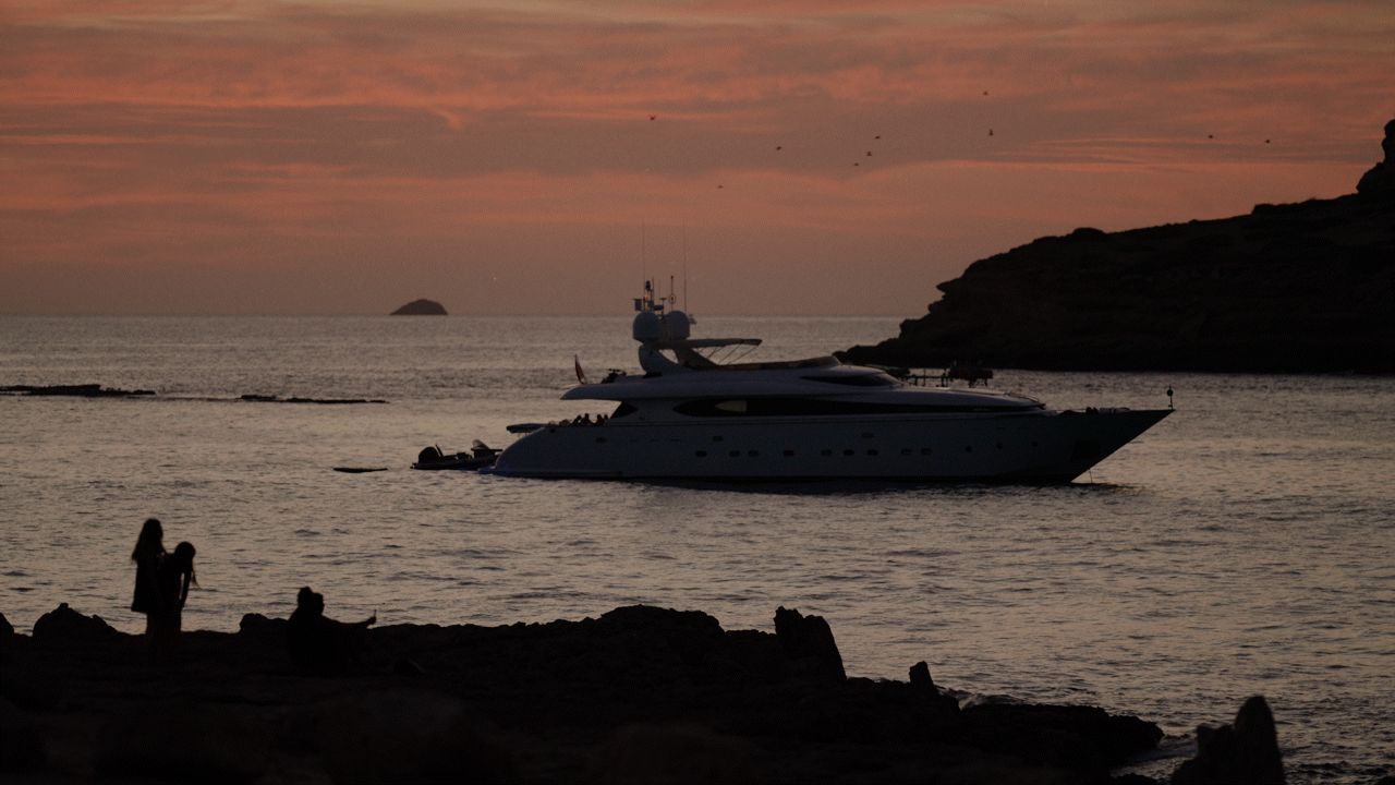 Barco en la costa de Ibiza durante el atardecer mediterráneo