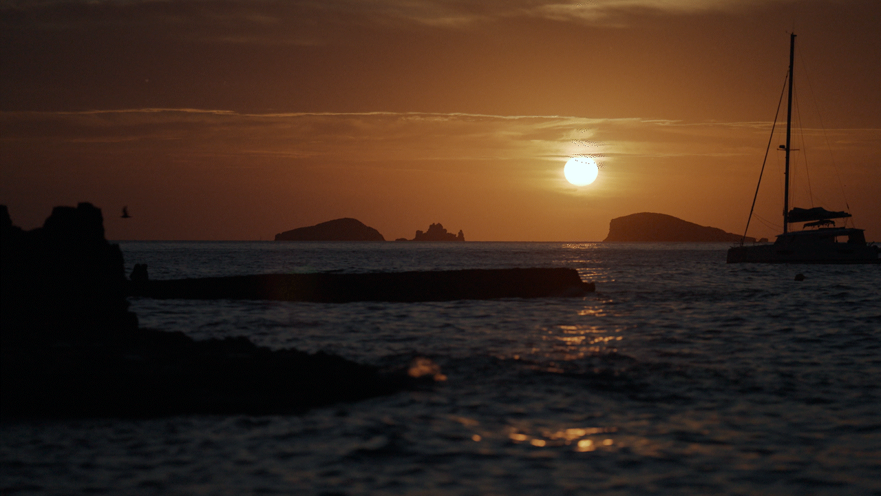 Puesta de sol en Ibiza con islotes de fondo y movimiento de agua