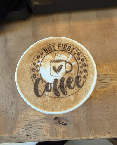 Design of "But First Coffee" and a cup on top of a hot latte.
