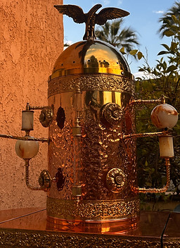A cylindrical copper structure that has a gold eagle at the top.
