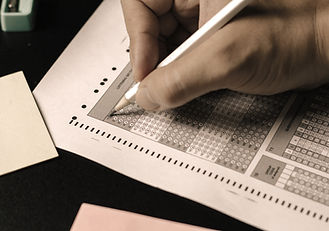 Filling in test answers on a standardized test bubble sheet with a pencil