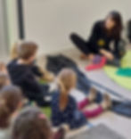 Enfants écoutant l'histoire de Jojo l'escargot en classe.