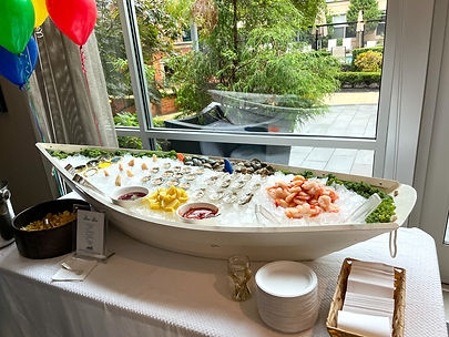 Elegant Raw Bar Display: A beautifully arranged seafood platter featuring oysters, clams, shrimp, and colorful garnishes.