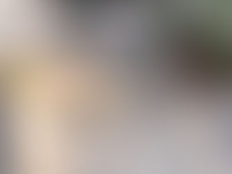 long mdf plank being scored with a number of cuts to enable flex. Wooden batten and tools visible on pavement backdrop with flowerbed to top right.