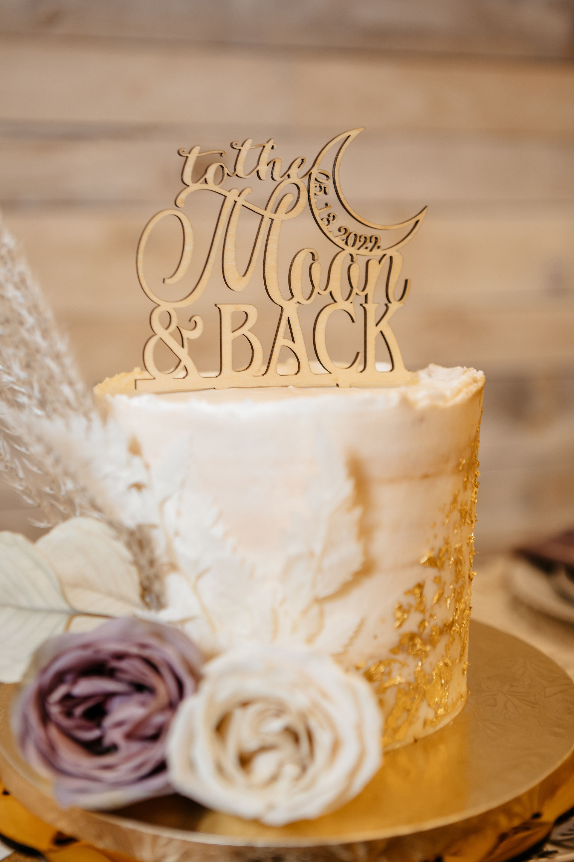 wood cake topper that says to the moon and back