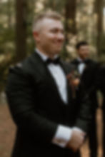 Groom watching bride walk down the aisle during an outdoor ceremony at Abloom Farm